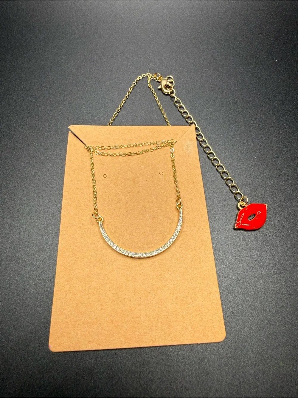 Gold-Tone Crystal Curved Bar Necklace with Red Lip Charm